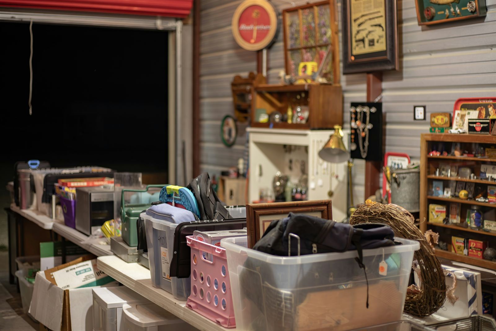 Organized yard sale setup with tables, storage bins, and household items arranged for an easy-to-shop garage sale. Organized yard sale setup with tables, storage bins, and household items arranged for an easy-to-shop garage sale.